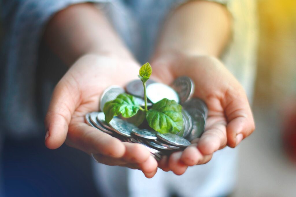 Frasco con monedas y una planta creciendo, símbolo del interés compuesto